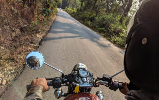 motorcycle rider on narrow road through the woods