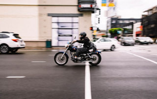 person riding a motorcycle amongst cars