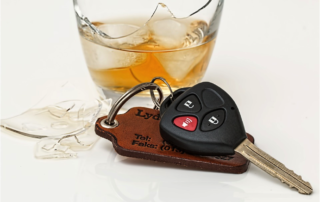 car keys sitting next to a broken whiskey glass