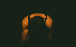 a man holding his head in his hands in a dark room