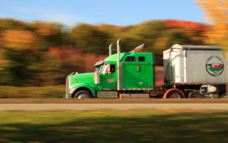 a tractor trailer driving fast on a road