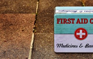 an old first aid case tin on a brick sidewalk