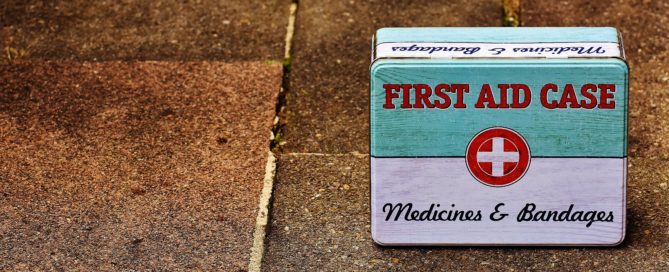 an old first aid case tin on a brick sidewalk