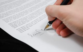 hand signing a legal document