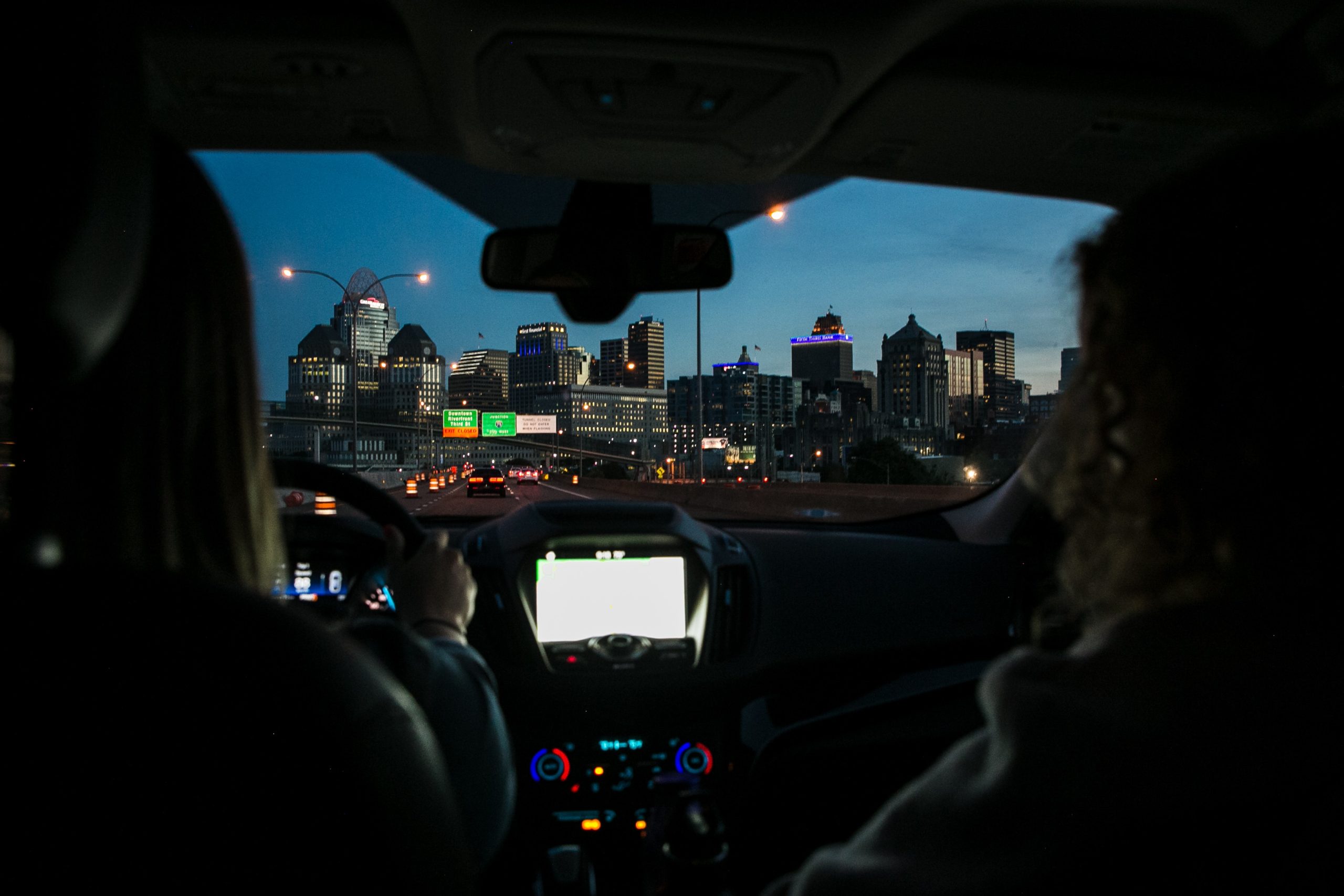looking through car windshield of cityscape at dusk