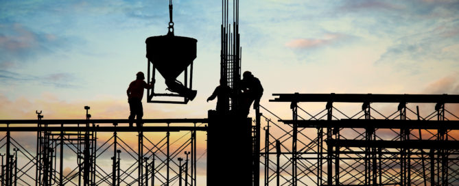 silhouette of construction workers on scaffolding