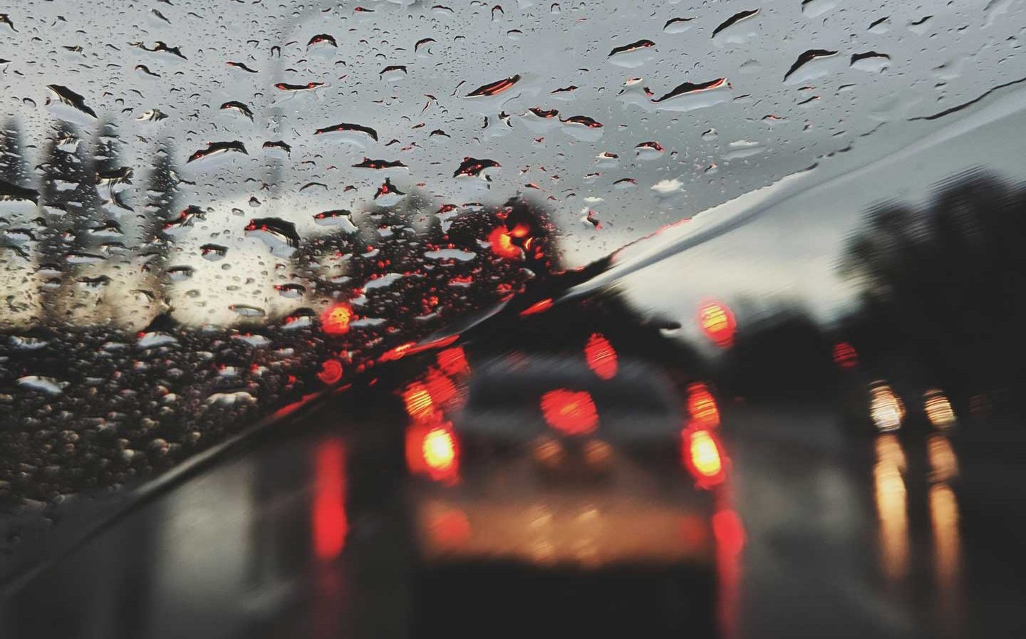 car lights through a rain streaked car windshield