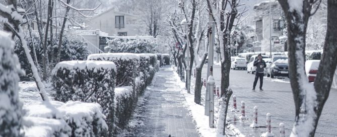 snowy sidewalk and street in a town